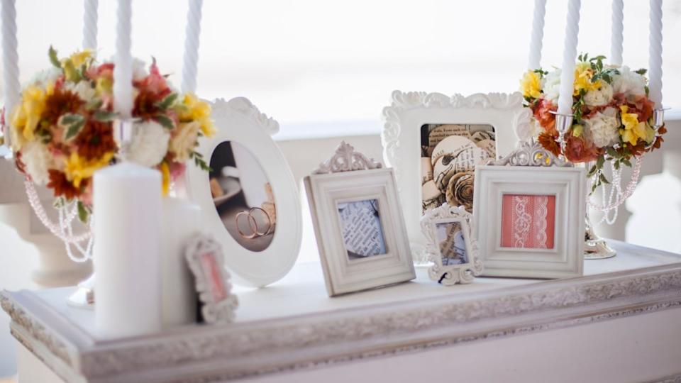 khabarovsk, russia, 20.10.2013 Decorated wedding table with candles, flowers and picture frames showing rings and lace for a romantic celebration.