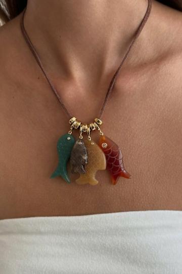 A woman wearing a charming fish necklace.