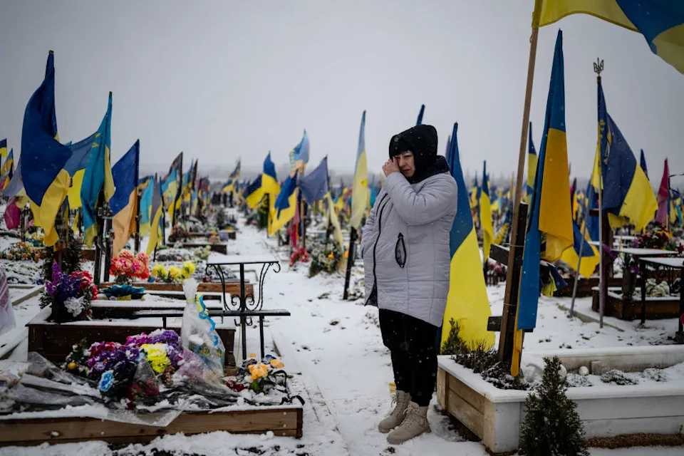 KHARKIV, UKRAINE - FEBRUARY 18: Lesia Komaritska, 41, visits the grave of her husband, who was drafted into the Ukrainian army in January 2023, and killed in Bakhmut in February 2023, and buried in a section of the cemetery reserved for soldiers on February 18, 2024, in Kharkiv, Ukraine. Two years after Russia's all-out invasion of Ukraine, the Ukrainian people are dealing with the loss of tens of thousands of soldiers and civilians, and they are exhausted, though remarkably resilient. (Photo by Lynsey Addario/Getty Images)