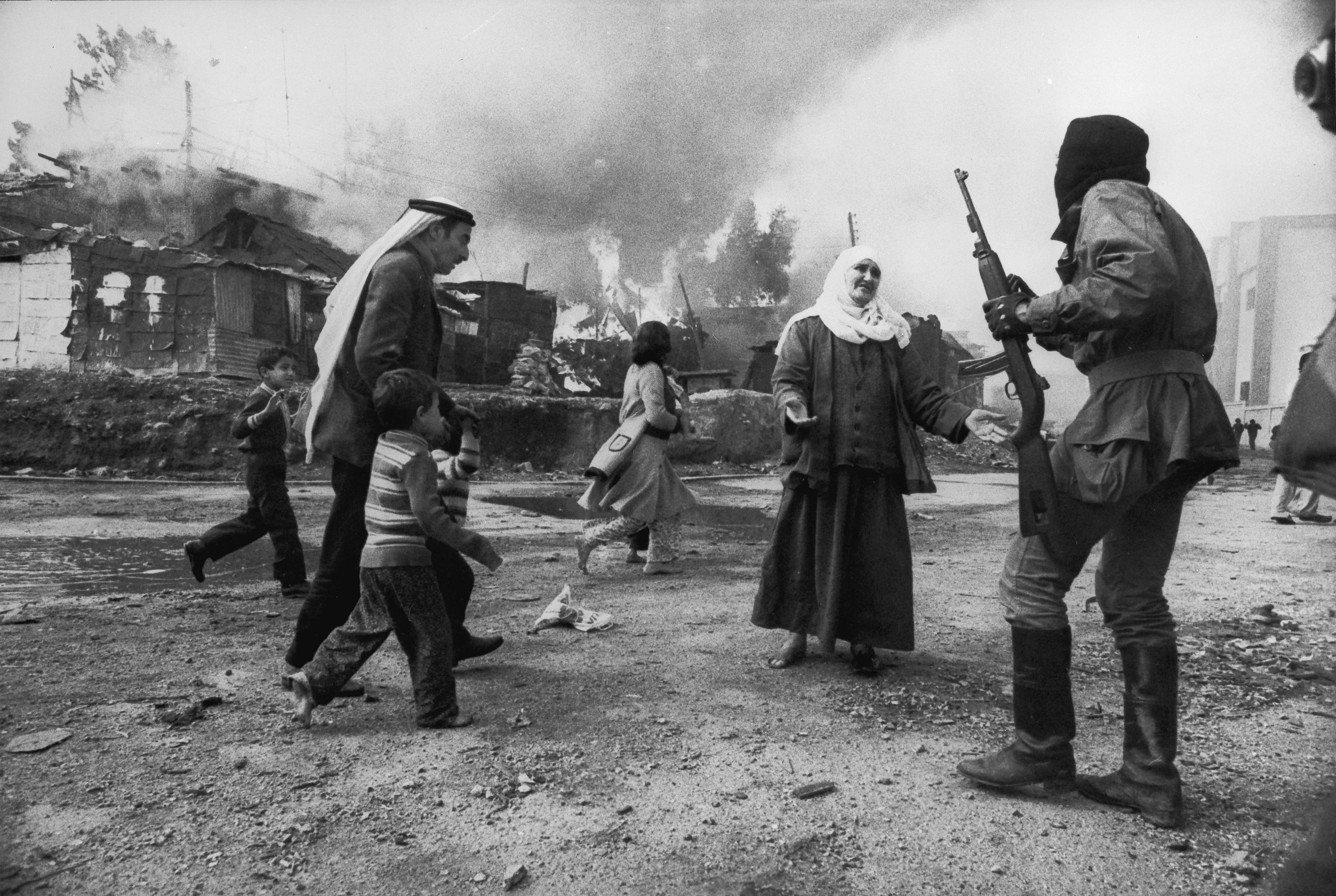 A Palestinian woman appeals to Christian soldiers in Beirut as a man tries to take children to safety during the Lebanese civil war, 19th January 1976. (Photo by Francoise De Mulder/Roger Viollet via Getty Images)