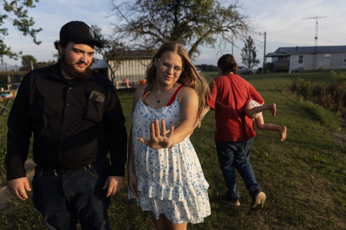 The little white girl held out her hand to look at the engagement ring. He is standing by his bodyguard outside someone's house. 