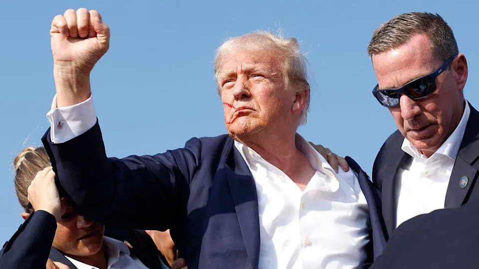 BUTLER, PENNSYLVANIA - JULY 13: Former Republican presidential candidate Donald Trump is escorted by US Secret Service agents after being shot during a rally on July 13, 2024 in Butler, Pennsylvania. Butler County District Attorney Richard Goldinger said the shooter died after wounding former US President Donald Trump, killing one audience member and wounding another in the shooting. (Photo by Anna Moneymaker/Getty Images).
