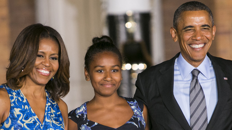 Michelle, Sasha, and Barack Obama smile in blue