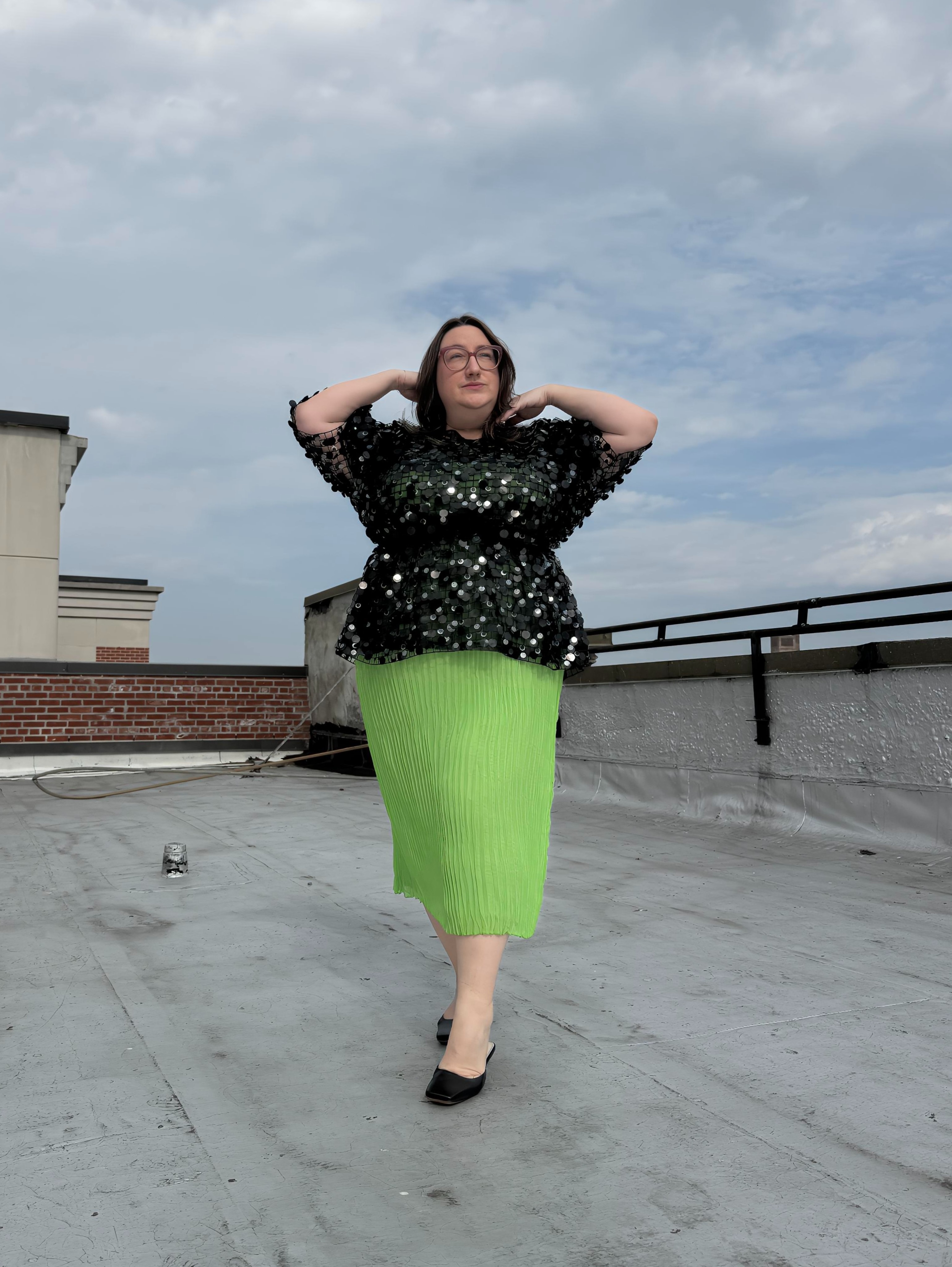 Sarah Chiwaya poses in an embroidered peplum top in a light green dress.