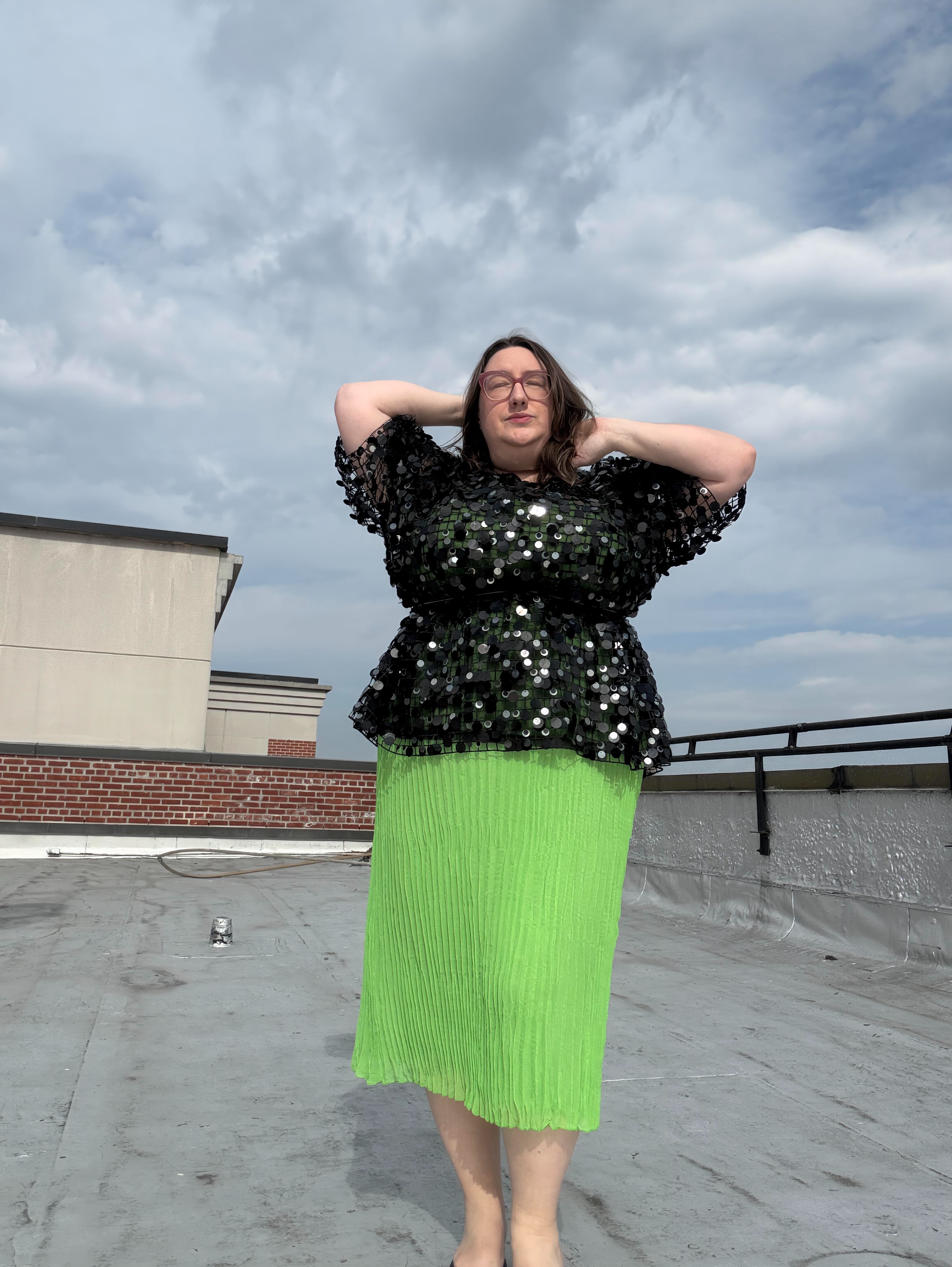 Sarah Chiwaya poses in an embroidered peplum top in a light green dress.