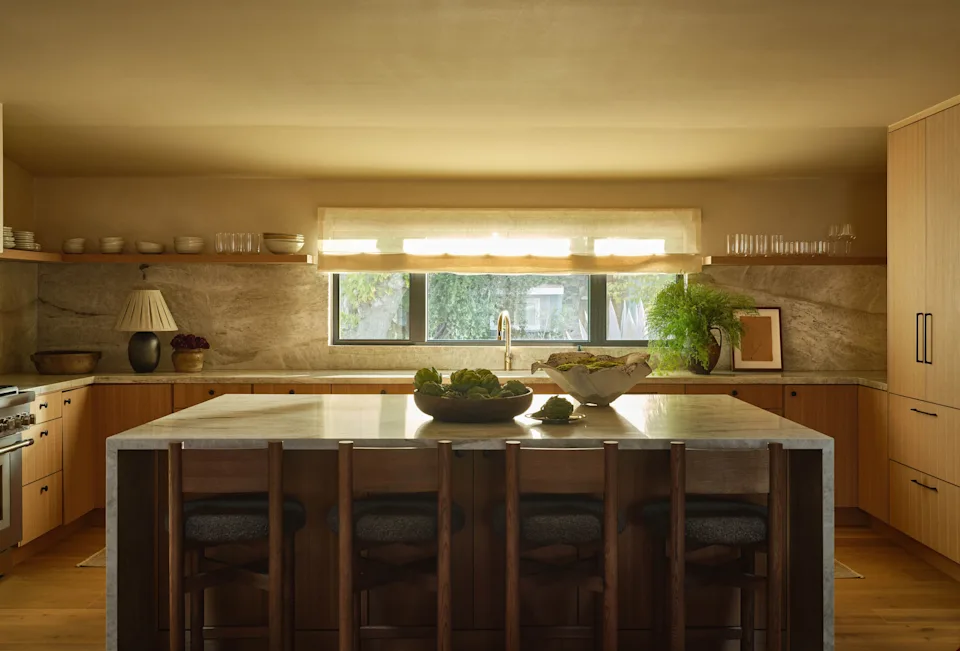 In the kitchen, Taj Mahal stone runs through the counters and backsplash, giving the space a sense of calm. Solis installed a lamp by ceramic artist Victoria Morris—whose Altadena studio was destroyed in the Eaton fire—in a custom shade. Other accessories include a Willy Guhl planter from Big Daddy's Antiques.