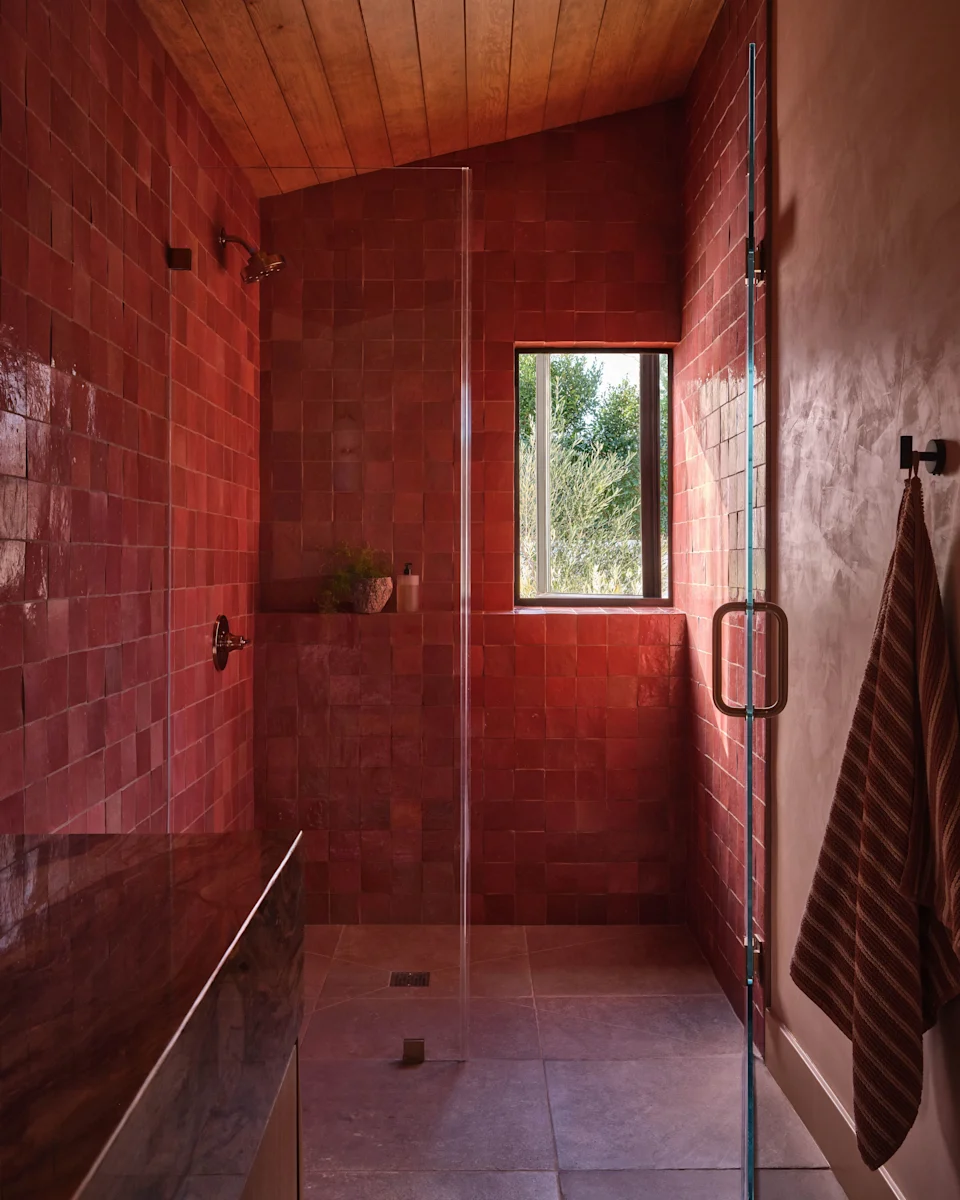 In the guest bathroom, Portola Paints Clay walls and tumbled limestone floors contrast with the glossy surfaces of Moroccan zellige.