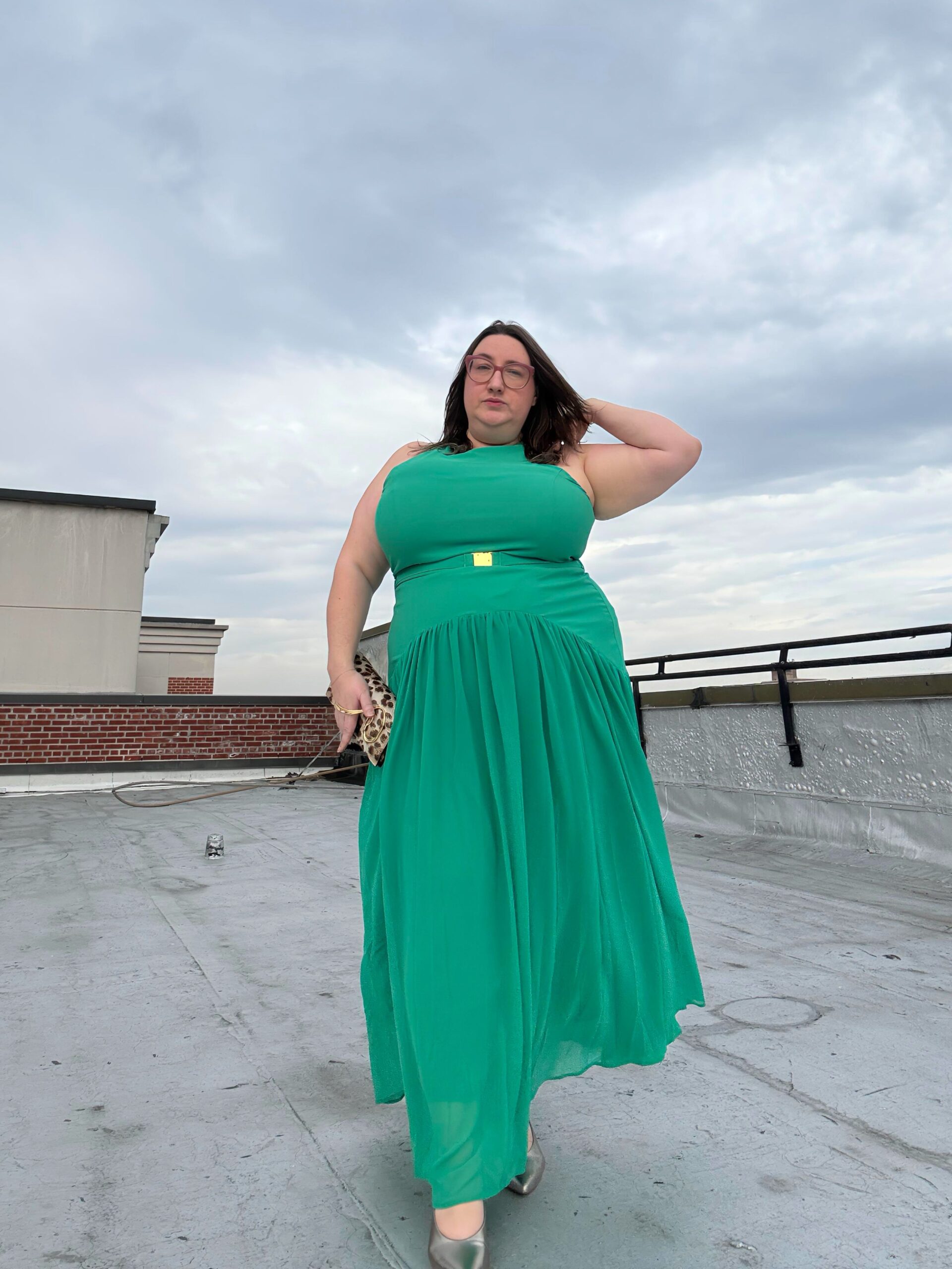 Sarah Chiwaya wore a green waist dress with an animal print clutch